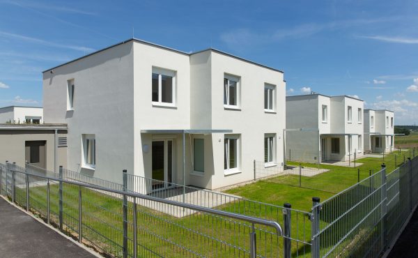 Moderne Doppelhaushälften mit Garten und Zaun im Grünen. Ideal für Familien.